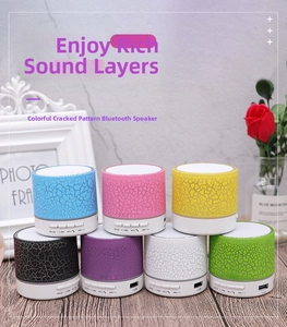 Group of crackle pattern mini bluetooth speakers in multiple colors on a wooden table