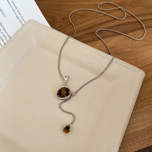 Detailed view of resin flower bottle pendant necklace with silver chain and brown beads