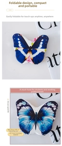 Detail of portable blue butterfly folding makeup mirrors on a newspaper background