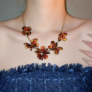 Detail of amber leopard print petal necklace worn by model showing elegant texture