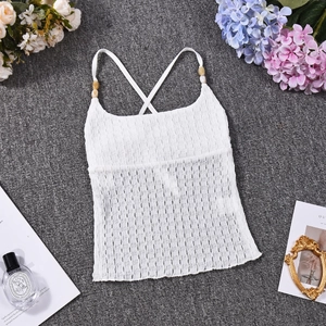 Detailed view of white halter crop top with textured fabric and beaded strap accents