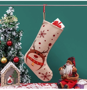 Nahaufnahme des beigen Nikolausstrumpfes mit Rentier-Print und weißem Geschenkkarton