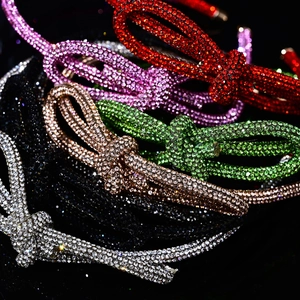 Close-up of sparkling rhinestone bow headbands in various vibrant colors stacked together