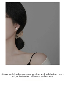 Detailed side view of silver stud earrings featuring zircon stone and heart cutout design