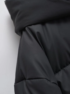 Detail shot of the matte black windproof fabric and warm insulation of the winter jacket