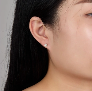 Detailed macro view of sparkling sterling silver sunflower stud earring worn by a model