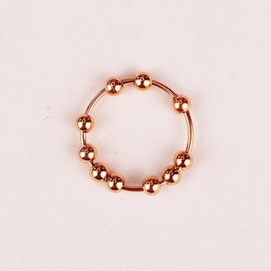 Detail view of ten rotatable rose gold beads on an anti-anxiety stainless steel ring