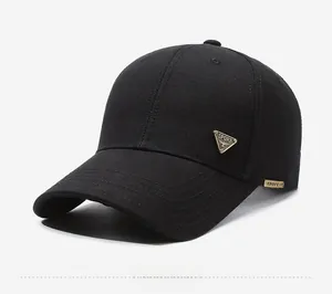 Detail view of black cotton baseball cap showing side sport metal badge and fabric texture