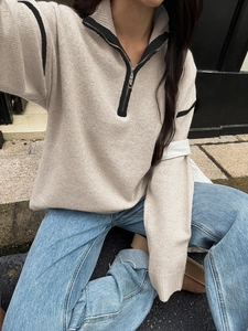 Beige quarter-zip knit sweater with black trim and relaxed fit for women's casual style
