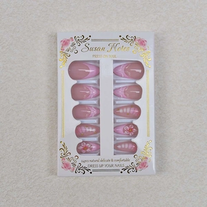 Detailed macro view of 24pcs pink 3D floral press-on nails with pearls and gold accents