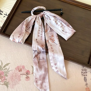 Close-up of a pink floral silk ribbon with Chinese calligraphy and a black hairpin