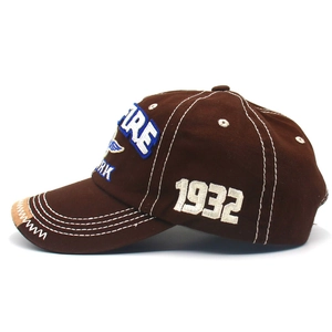 Detail of dark brown cotton baseball cap showing white contrast stitching and 1932 embroidery