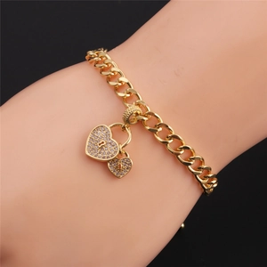 Close-up of gold plated Cuban chain bracelet featuring double zircon encrusted heart charms