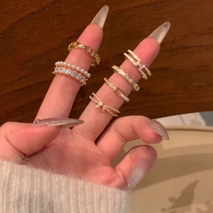 Elegant gold bow ring set with pearls and rhinestones shown on model hand