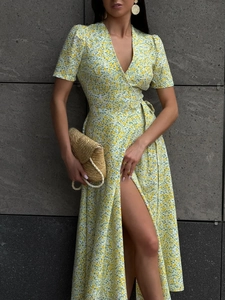 Detail of yellow floral wrap dress featuring a deep V-neck and adjustable waist tie