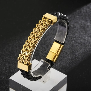 Macro detail of men's leather and gold steel bracelet with woven texture and magnetic clasp