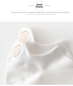 Close-up of white cotton ankle sock featuring a cute smiling face embroidery detail