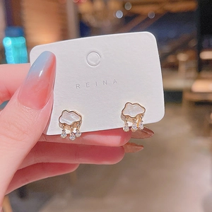 Detail of cloud earrings with hanging zircon raindrops on a white jewelry display card