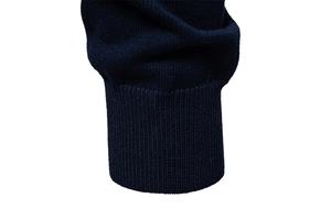 Macro detail of dark blue knit cardigan showing ribbed cuffs and fine textile texture