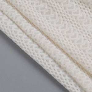 Gros plan sur un élégant tricot blanc texturé avec des motifs décoratifs en vagues