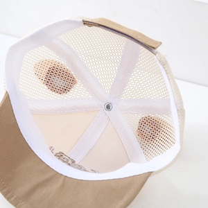 Internal detail of infant trucker hat showing breathable mesh and adjustable velcro strap
