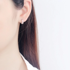 Detail of S925 silver rose gold mini hoop earring with pink shell inlay on ear