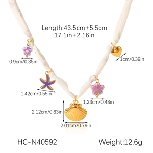 Vue détaillée du collier foulard avec pendentifs coquillage, étoile de mer et cœur en soie