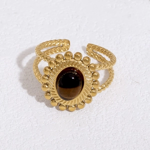 Detailed view of an 18k gold plated stainless steel ring with oval tiger eye stone