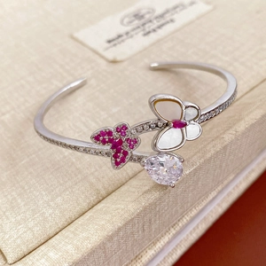 Detail of silver butterfly open bangle with red zircon pavé and pear-cut crystal drop