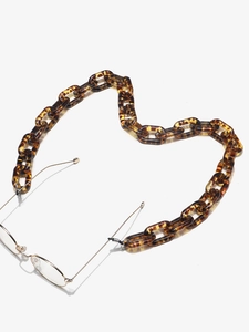 Detailed macro view of amber leopard resin links and metal clips on eyewear chain