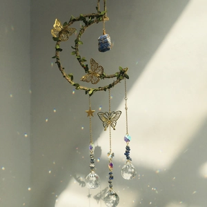Detail showing crystal prism ball on moon chime casting rainbow light on the wall