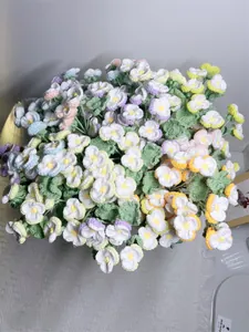 Detail of handcrafted pansy bouquet with colorful knitted flowers and green leaves