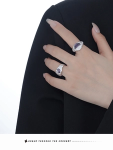 Macro view of irregular silver lava texture ring set with marquise purple gemstone