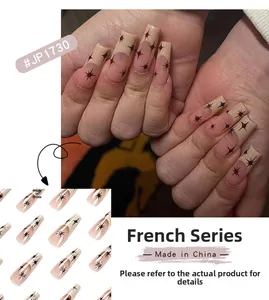 Detailed view of long coffin press-on nails with nude base and brown French star patterns