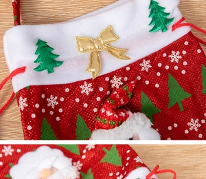 Close-up of drawstring Christmas gift bags with plush Santa and tree decorations