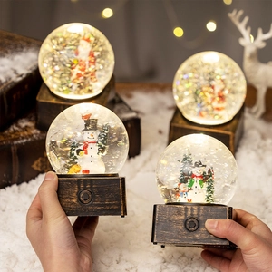 Boule à neige de Noël avec Père Noël et lumière LED sur socle en bronze