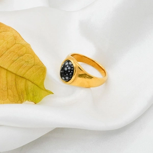 Detailed shot of a 18k gold plated ring with speckled agate stone on white silk