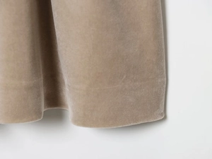 Vue macro détaillée de la texture du tissu en velours kaki sur l'ourlet de la robe