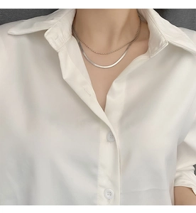 Detail of double-layer stainless steel necklace featuring a bead chain and flat snake chain
