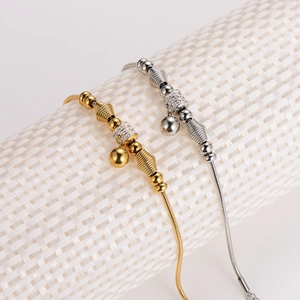 Elegant gold and silver beaded snake chain bracelets with sphere pendants on display