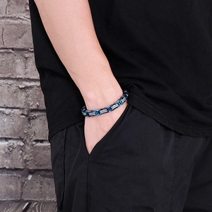 Detailed close-up of 8mm blue and silver stainless steel curb chain on male wrist