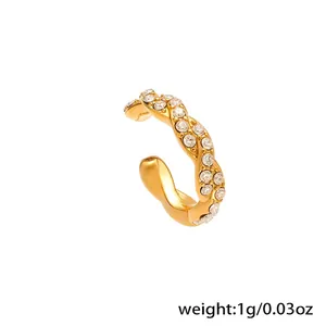 Detalle macro de un ear cuff de acero inoxidable chapado en oro 18k con piedras de circón