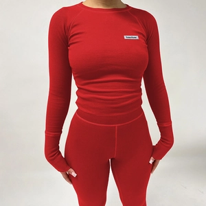 Détail de la texture côtelée rouge et du logo HAWTHAW sur l'ensemble de yoga ajusté