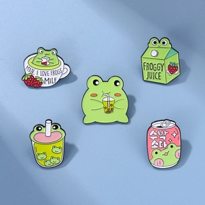 Détail de pins en émail grenouilles mignonnes avec motifs thé au lait et soda