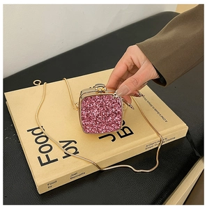 Detailed close-up of pink glitter mini acrylic bag with gold metal frame and chain strap