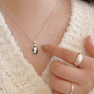 S925 sterling silver cameo necklace and wide ring set on model in white sweater