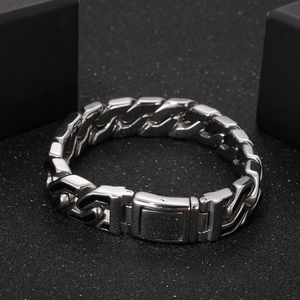 Detail of silver stainless steel curb chain bracelet with punk black stripes on black background