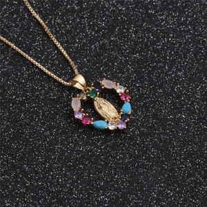 Close-up of gold heart pendant with Virgin Mary relief and multi-color crystals