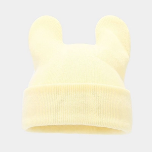 Detail of light yellow knit hat with cute round animal ears and ribbed texture