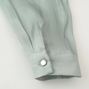 Elegant light green satin shirt cuff with silver button and textured fabric detail